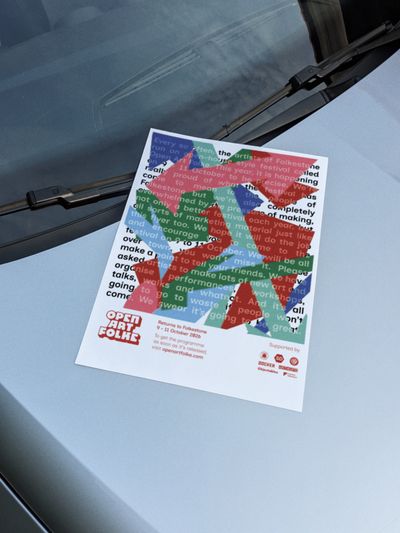Open Art Folke flyer on the hood of a car