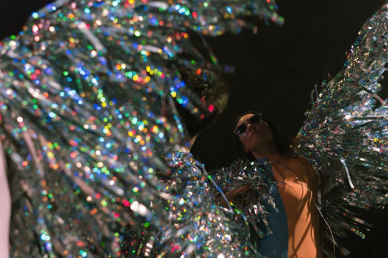 Stealing Sheep bandmates dancing on stage with sparkly outfits